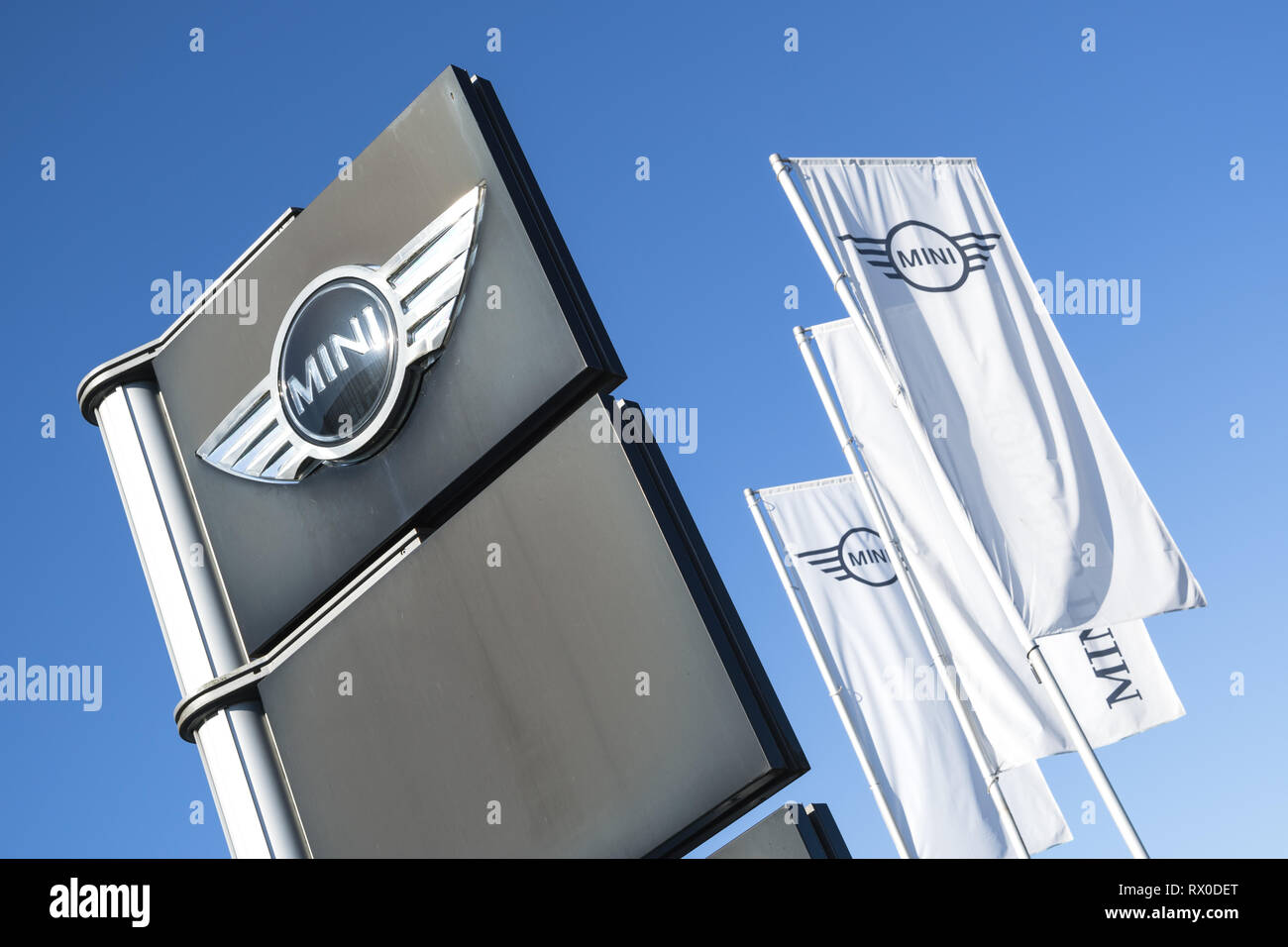 Mini dealership sign against blue sky. Mini is a British automotive marque, owned by BMW since 2000, and used by them for a range of small cars. Stock Photo