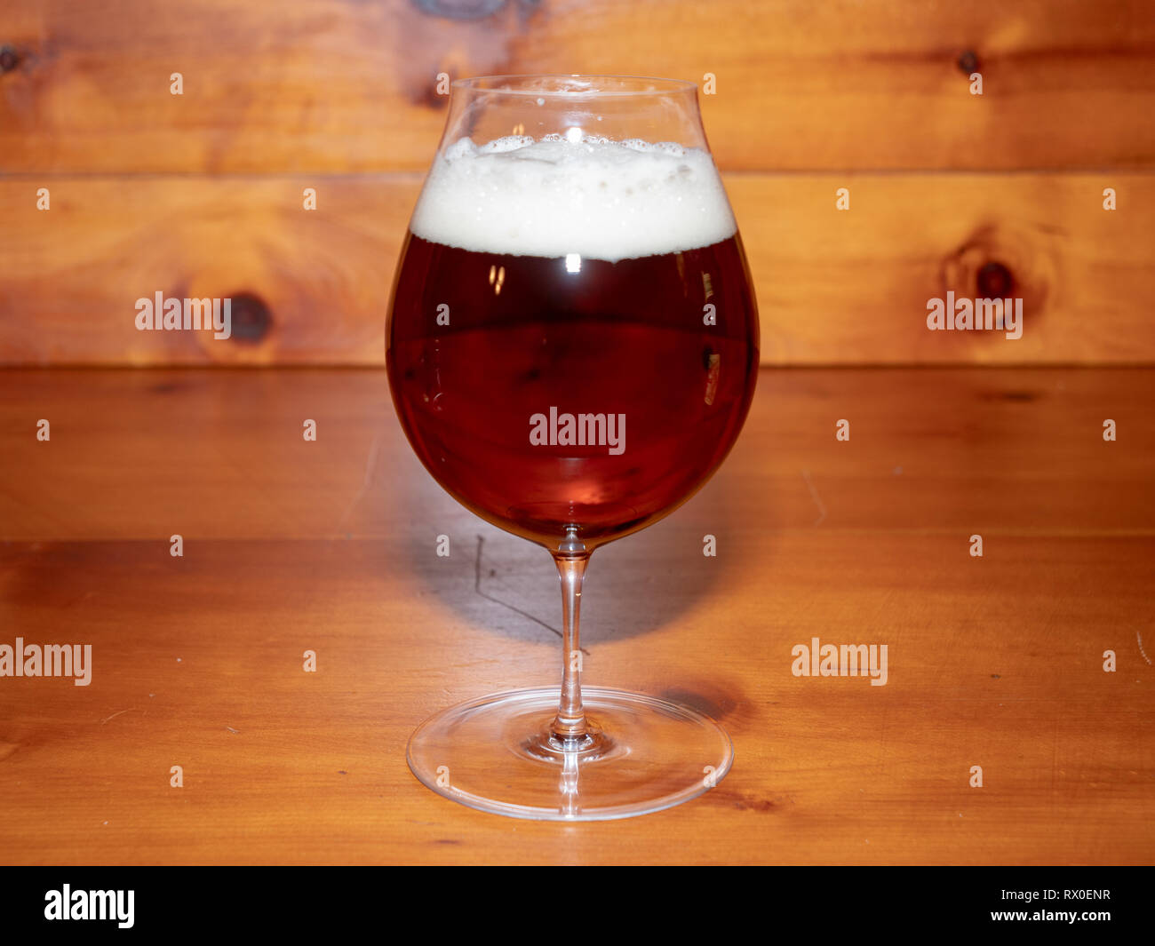 Refreshing, Amber Ale or Beer in a Tulip Shaped Glass on a Wood Background Stock Photo
