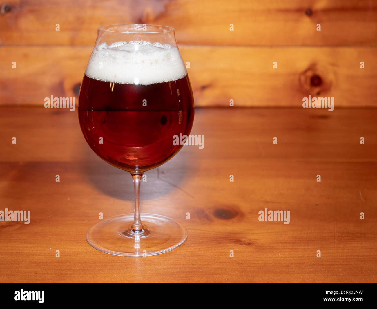 Refreshing, Amber Ale or Beer in a Tulip Shaped Glass on a Wood Background Stock Photo