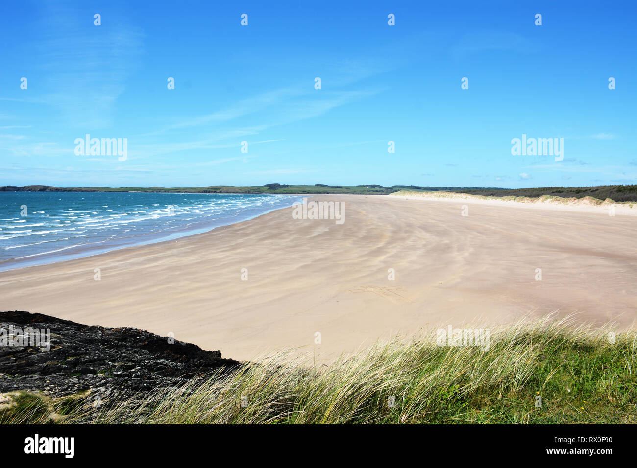 The beautiful and remote sandy beach on the northern side of Llanddwyn Island, which is set on the beautiful Isle of Anglesey in North Wales. Stock Photo