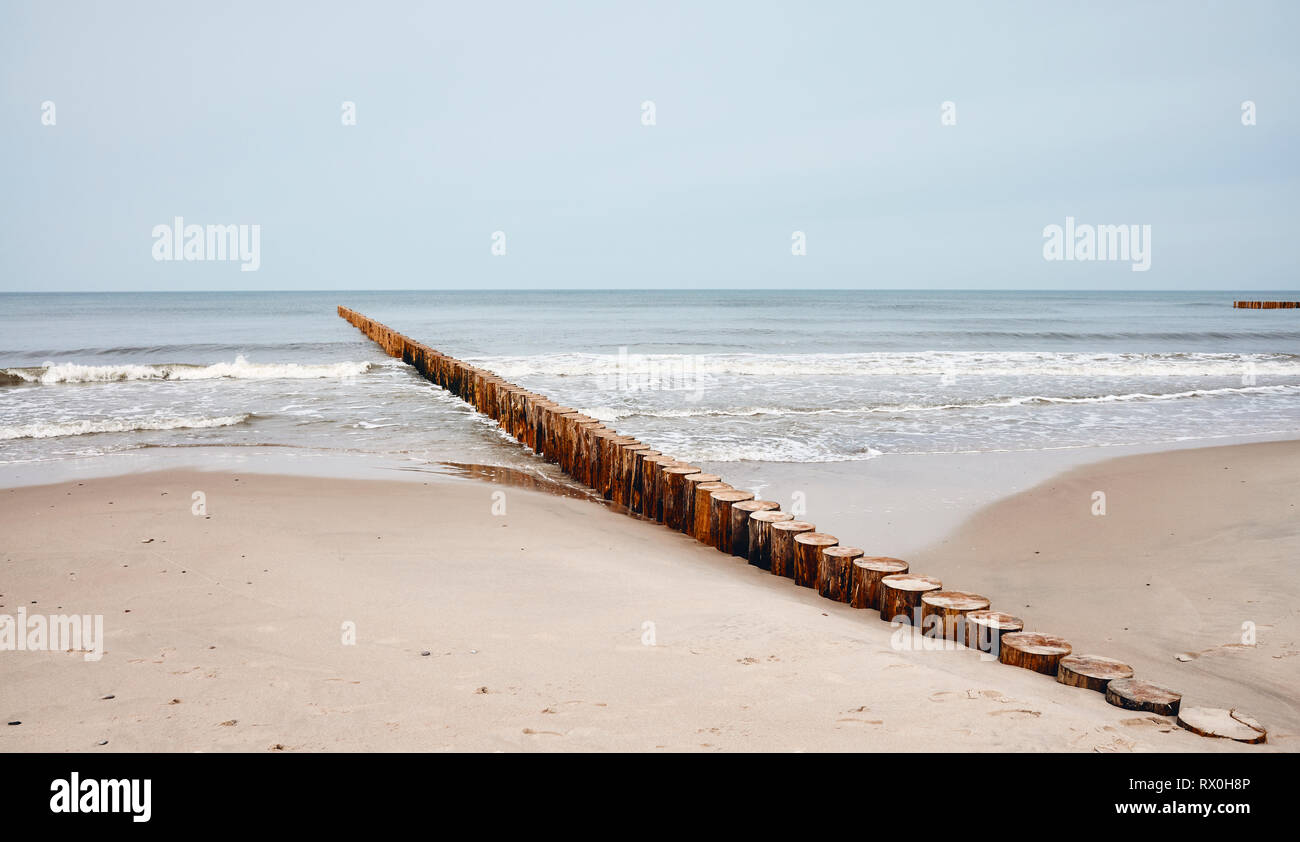 Seascape with wooden breakwater, color toning applied. Stock Photo