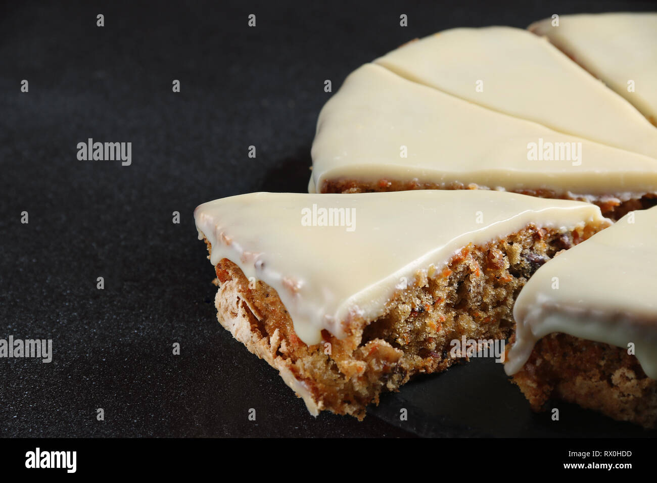 carrot cake with icing on dark back close up Stock Photo