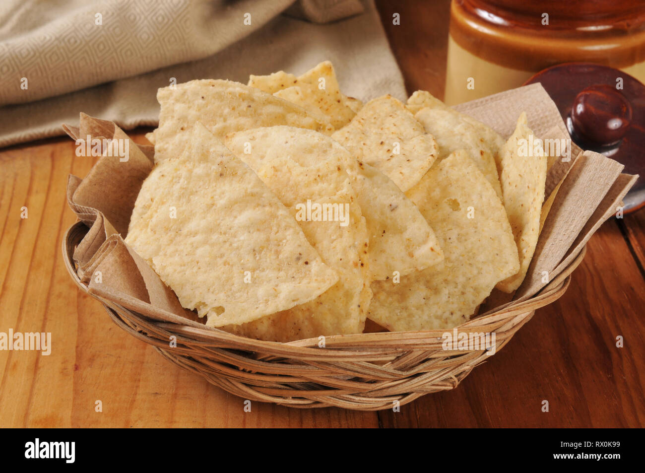 Restaurant style fried tortilla chips in a small basket with a salsa