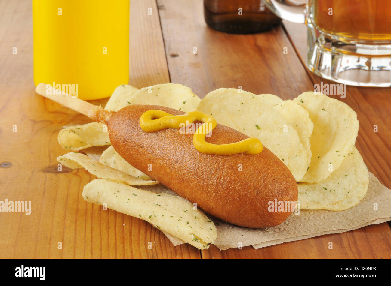 a corn dog with mustard and potato chips Stock Photo Alamy