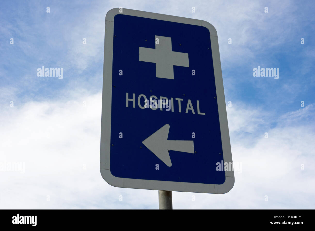 Australian hospital signage and blue painted metal hospital sign arrow points the way to the nearby hospital. Captured in Victoria, Australia. Stock Photo