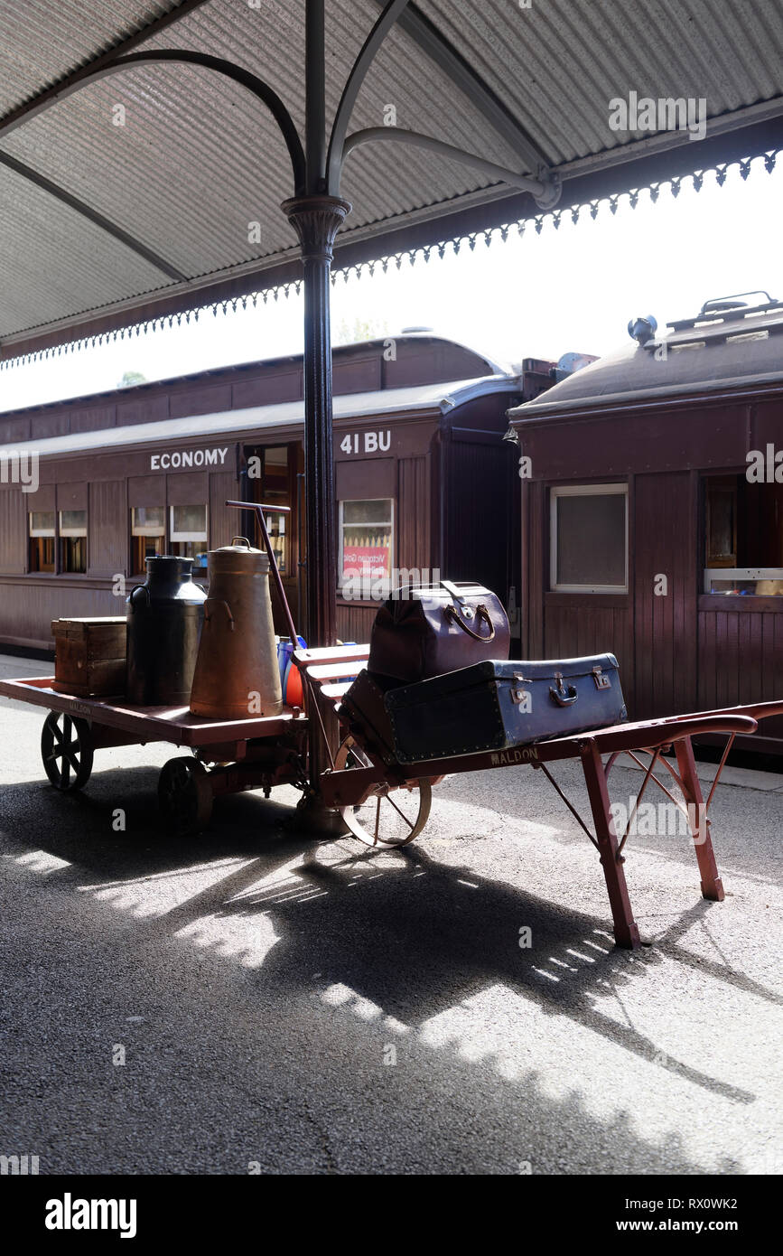 Old style luggage on porters’ trolley and cart on the platform, Maldon Railway station, Victoria, Australia. Opened in 1884, the historic station serv Stock Photo