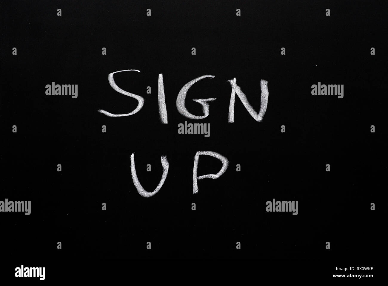 sign up written in white chalk on a black chalk board Stock Photo