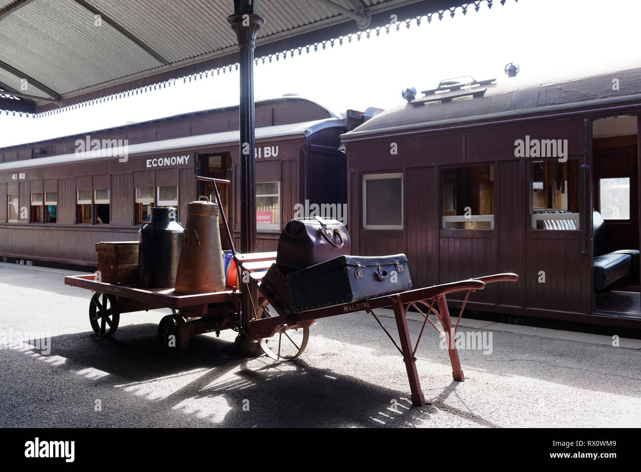 Old style luggage on porters’ trolley and cart on the platform, Maldon Railway station, Victoria, Australia. Opened in 1884, the historic station serv Stock Photo