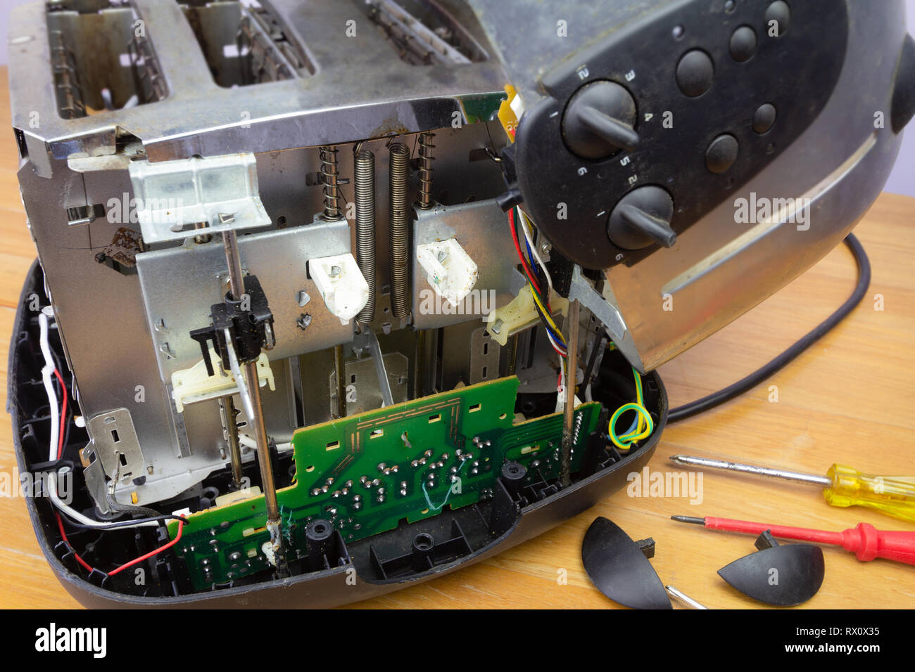 Concept Right to Repair, image showing consumer repairing toaster with tools. Reduce waste by repairing household appliances. Stock Photo