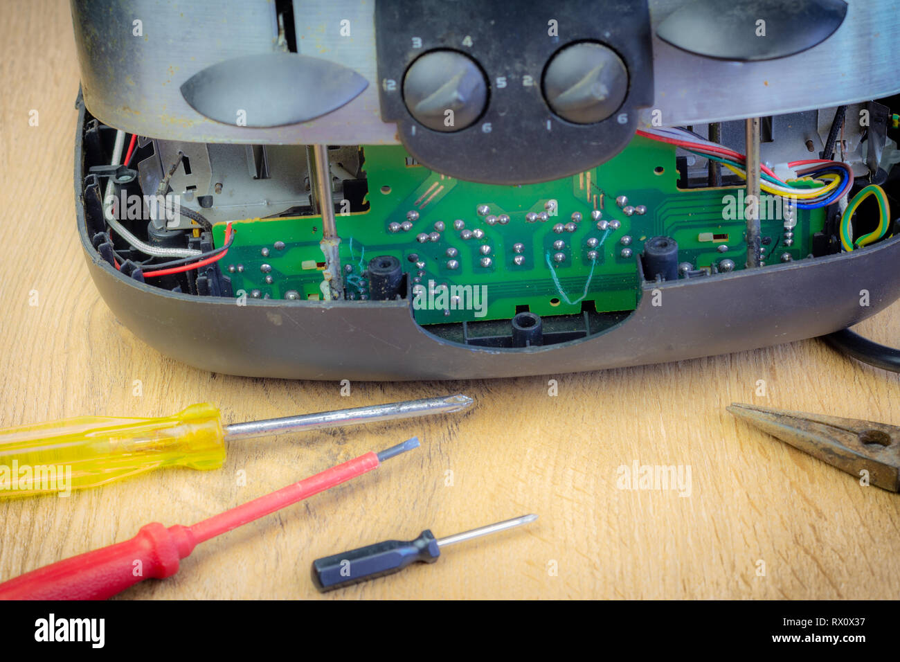 Concept Right to Repair, image showing consumer repairing toaster with tools. Reduce waste by repairing household appliances. Stock Photo