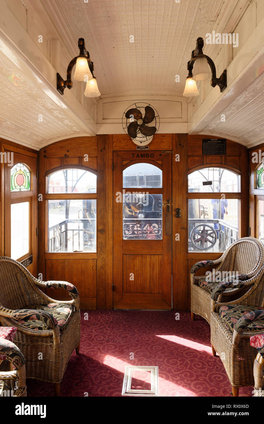 Lounge with cane chairs and art nouveau fittings of the Tambo Parlour Car, a first-class carriage built in 1919, Maldon railway station, Victoria, Aus Stock Photo