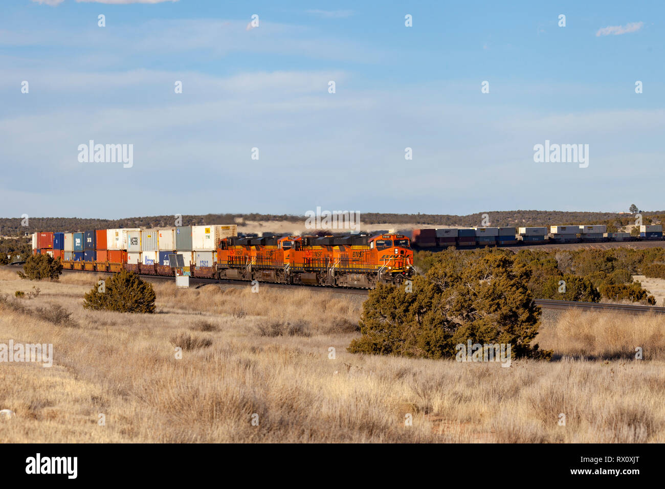 Freight train rounds a curve in New Mexico desert Stock Photo
