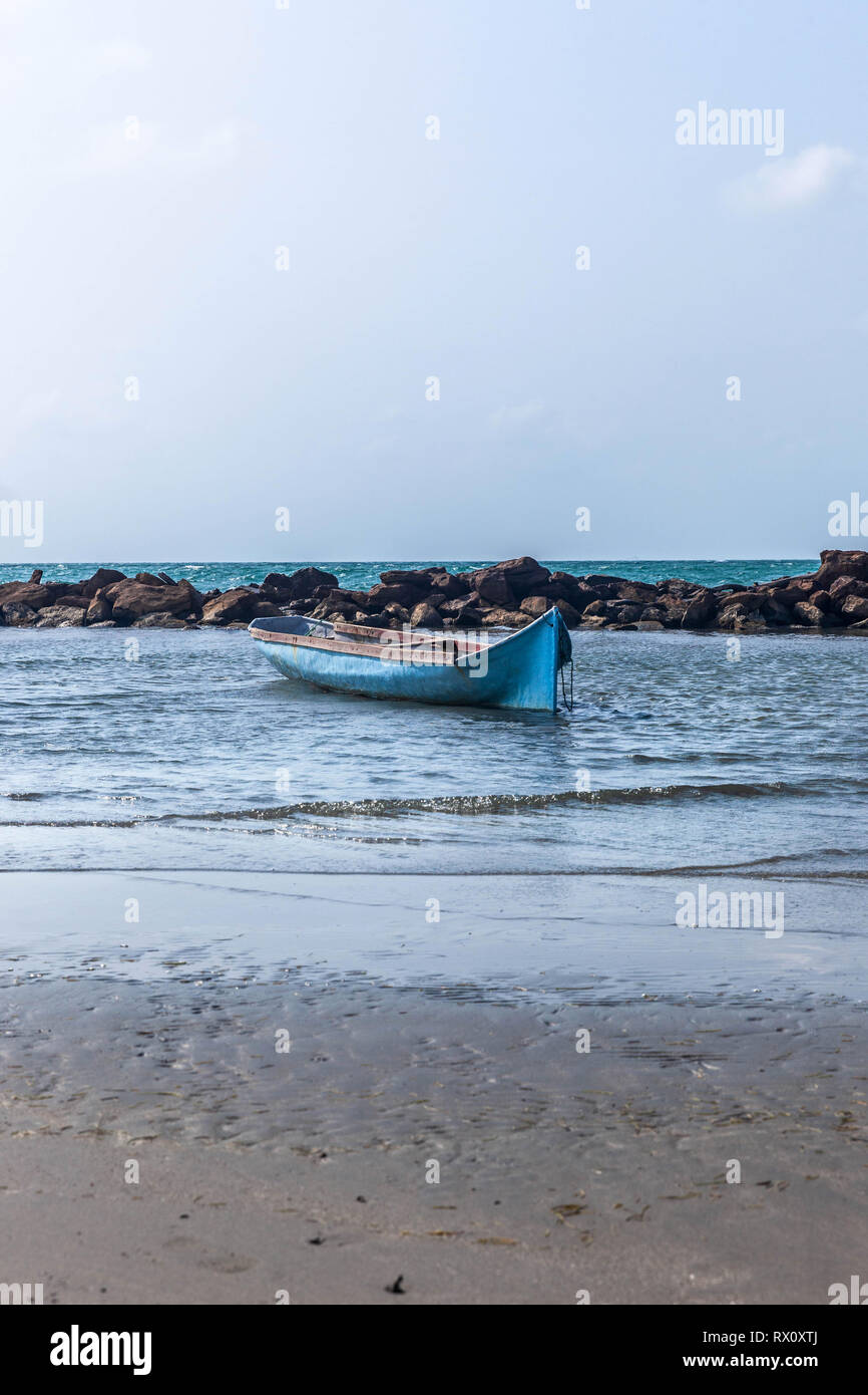 Empty canoe anchored on a beach of Coveñas, Colombia. Stock Photo
