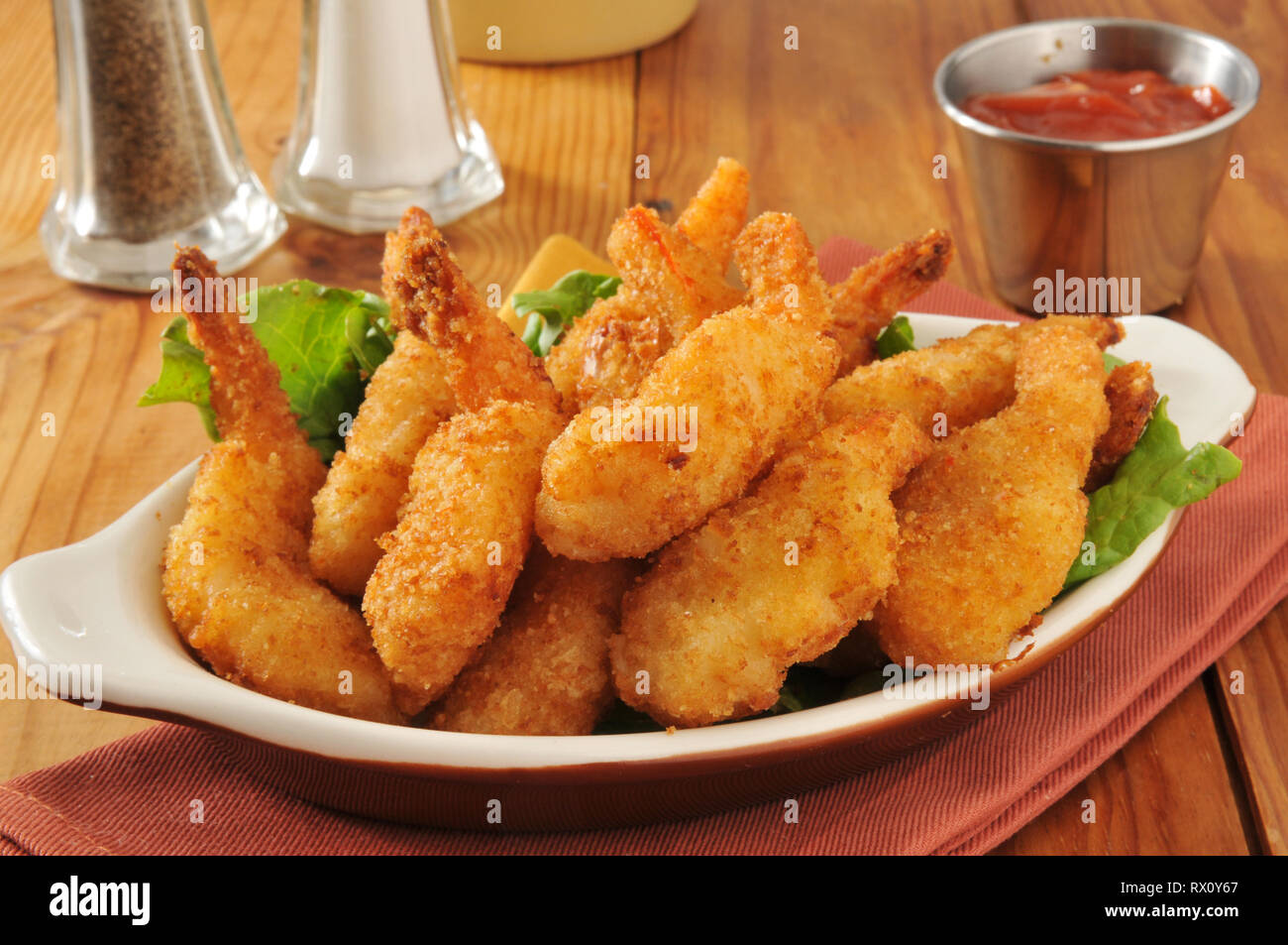 Deep fried butterfly shrimp in a bowl with cocktail sauce Stock Photo