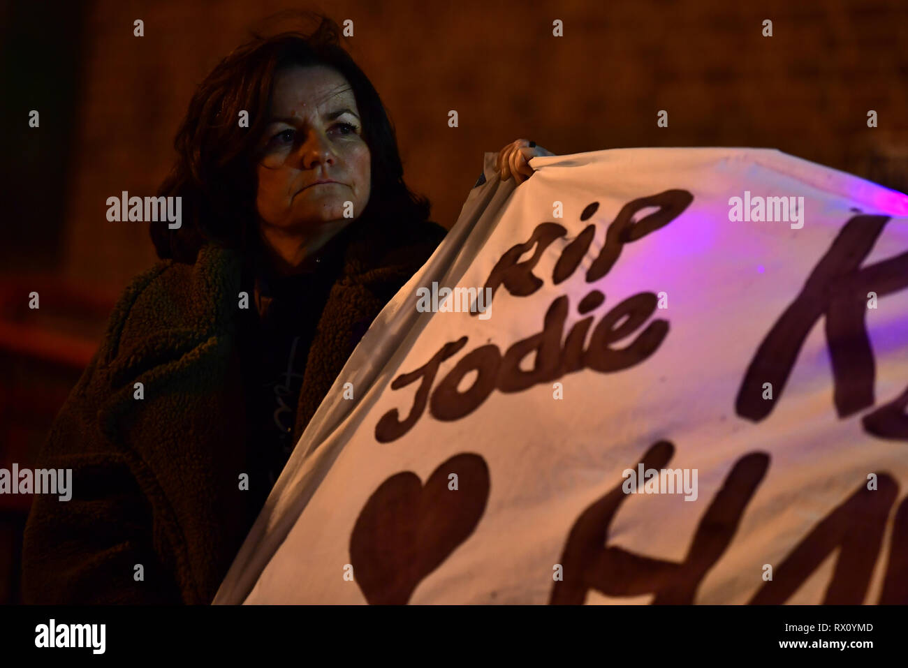 A woman holds up a banner in Romford town centre as part of a protest of the fatal stabbing of Jodie Chesney, who was playing music with friends near a children's playground at Harold Hill, east London, on Friday when she was knifed in the back in a seemingly motiveless attack. Stock Photo