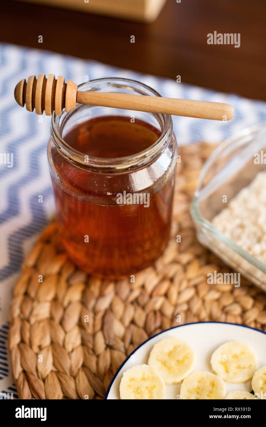 Honey jar with wooden honey dipper on top of it Stock Photo Alamy