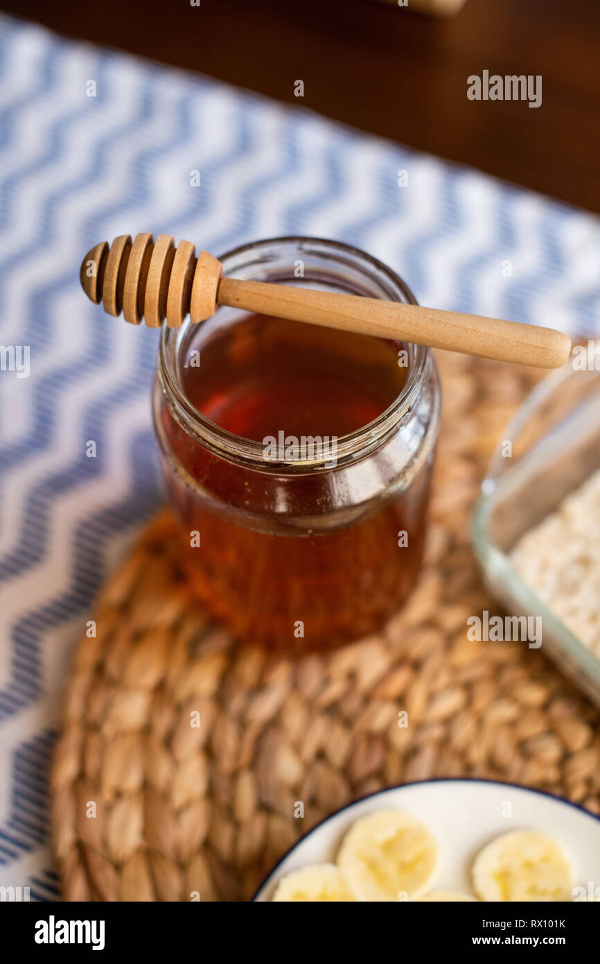Honey jar with wooden honey dipper on top of it Stock Photo Alamy