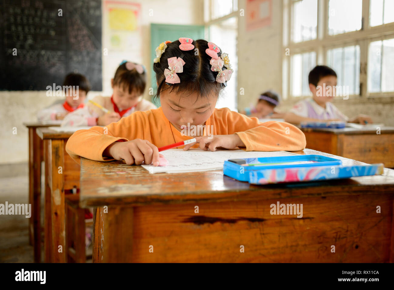 Elementary age school children attending class in a rural classroom in the Guangxi region of central southern China. Stock Photo