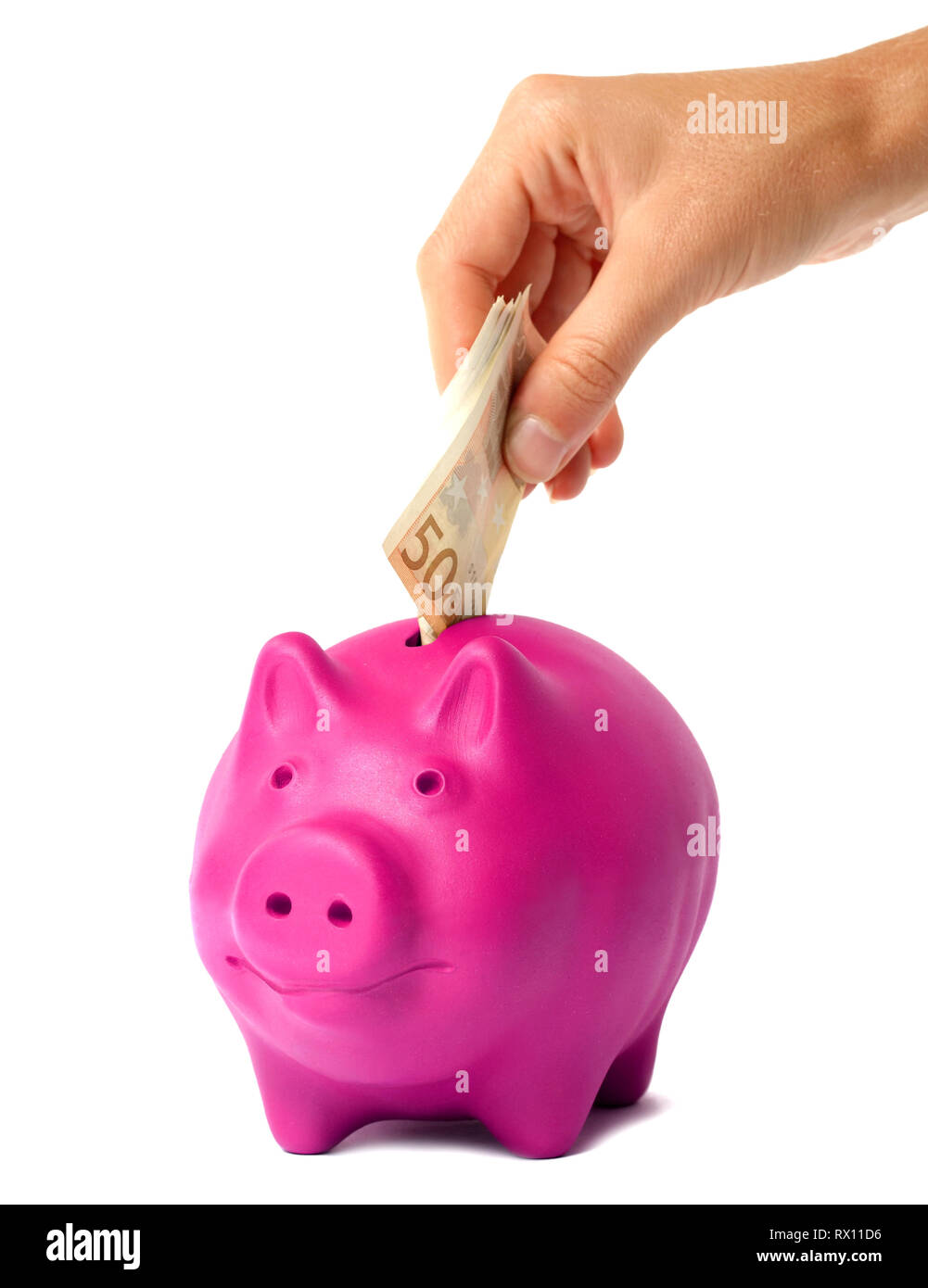 Hand putting money into the pink piggy bank Stock Photo - Alamy