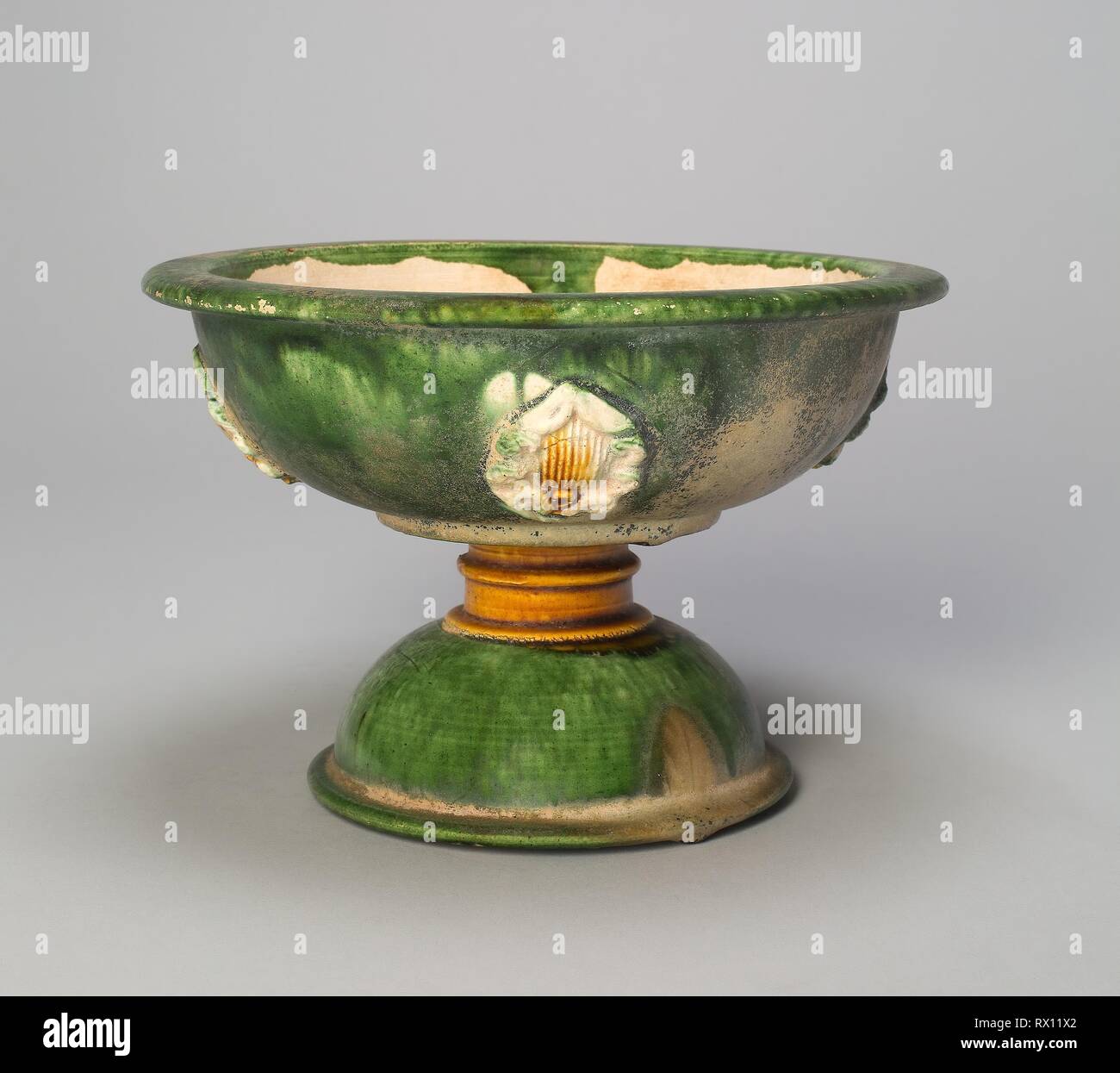 Stem Bowl with Foliate Medallions. China. Date: 700 AD-750 AD. Dimensions: H. 11.9 cm (4 11/16 in.); diam. 18.0 cm (7 1/16 in.). Earthenware with three color (sancai) lead glazes and underglaze molded decoration. Origin: China. Museum: The Chicago Art Institute. Stock Photo