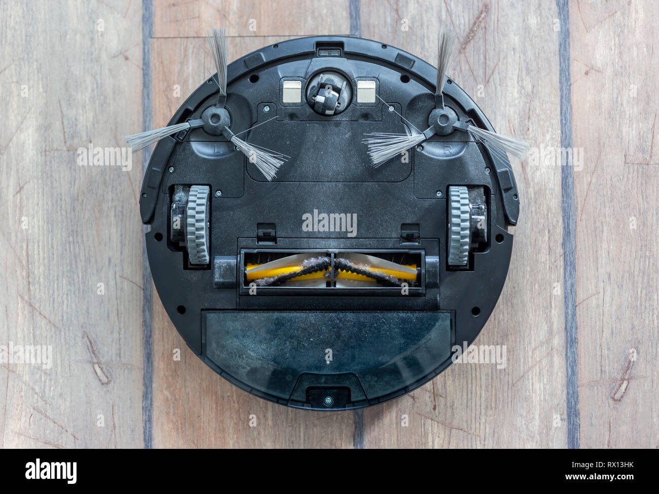 Robot Vacuum Cleaner Upside Down On The Floor Covered With Dust