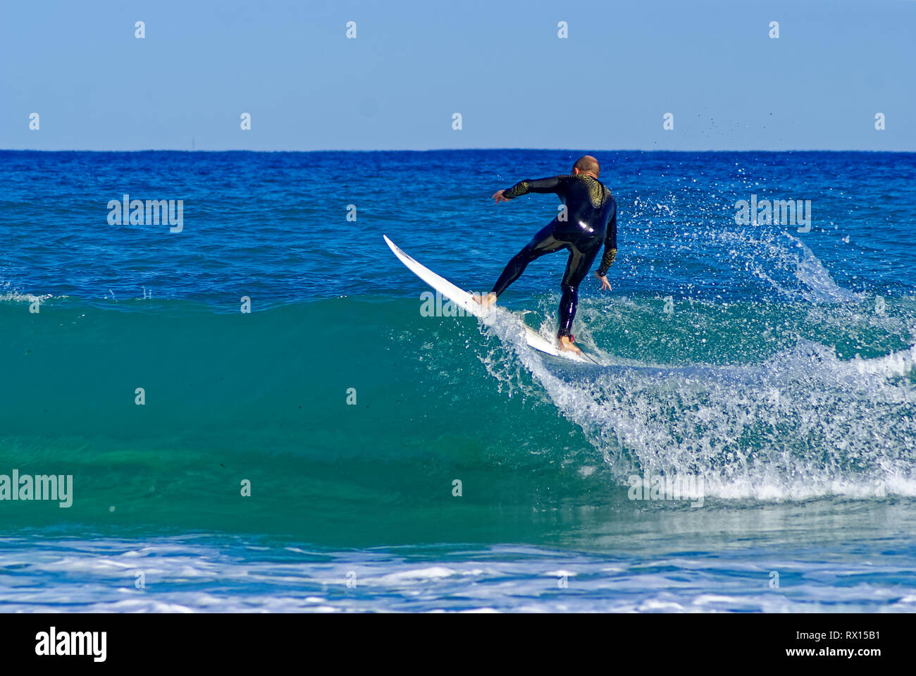 Surfer in black wet suit surfing on the crest of wave in mediterranean ...