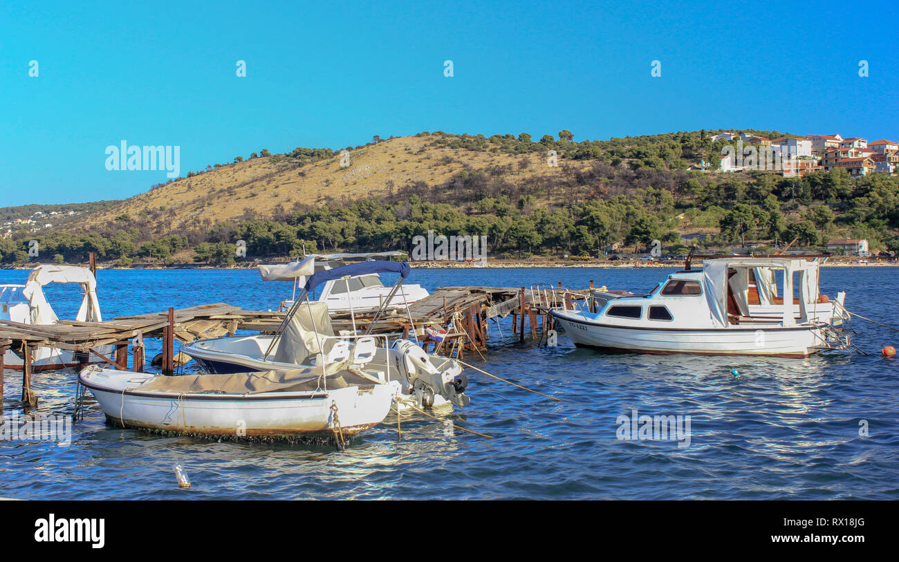 Motor boats moored up on a an old rickety wooden jetty near Trogir, Dalmatia, Croatia Stock Photo