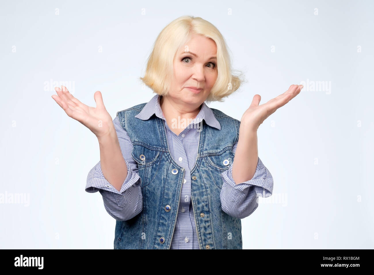 Angry old woman arguing and shrugging her hand Stock Photo