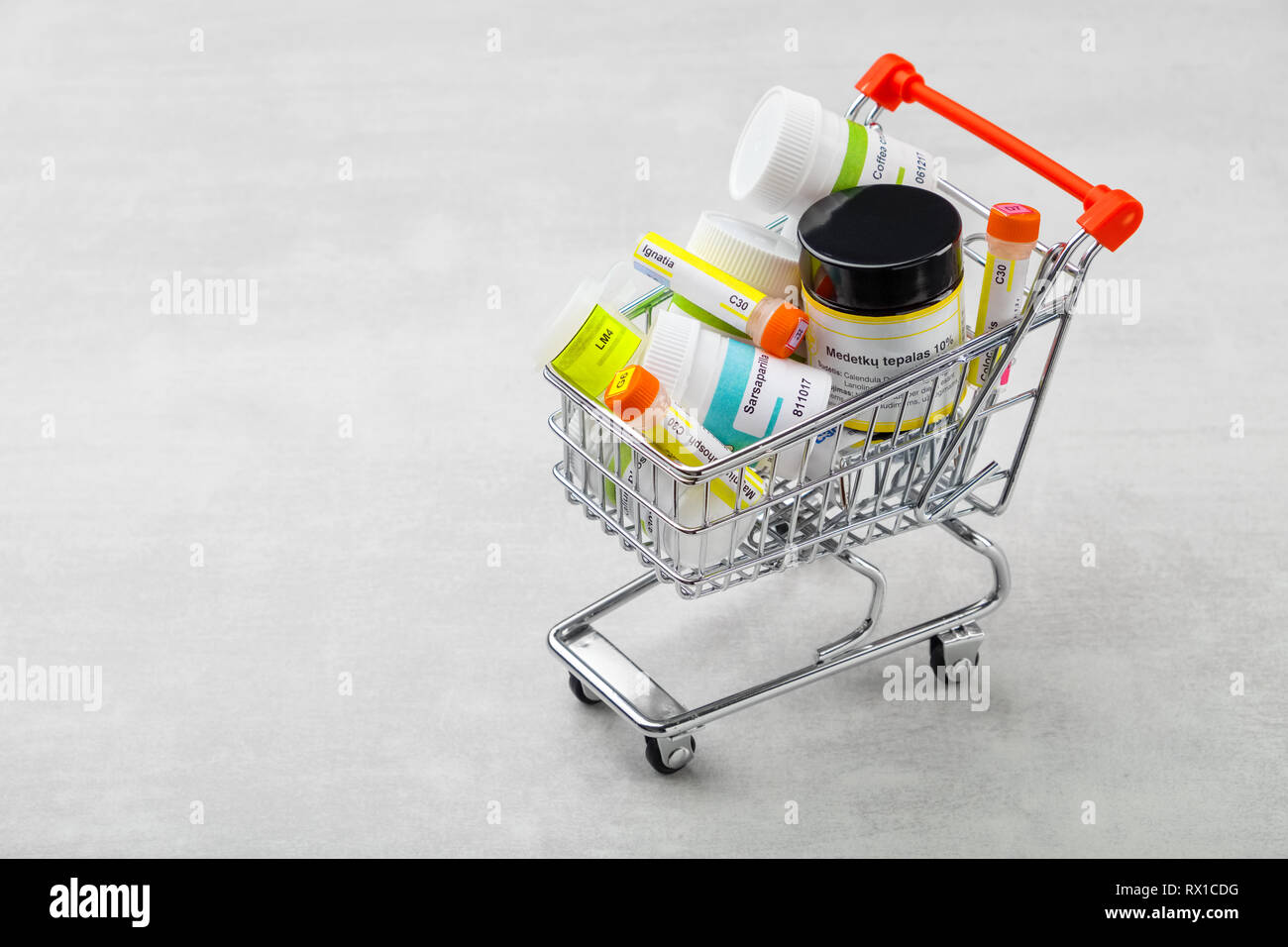 Mini shopping cart full of homeopathic remedies with typical international names. Homeopathy concept. Stock Photo