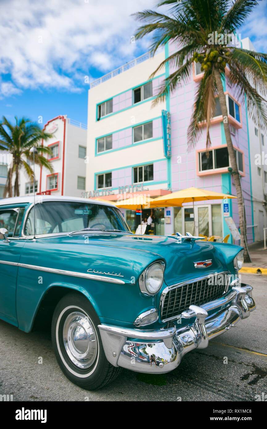 MIAMI - JANUARY 12, 2018: A bright blue classic car parked in South Beach reflects the Art Deco architecture on Ocean Drive. Stock Photo