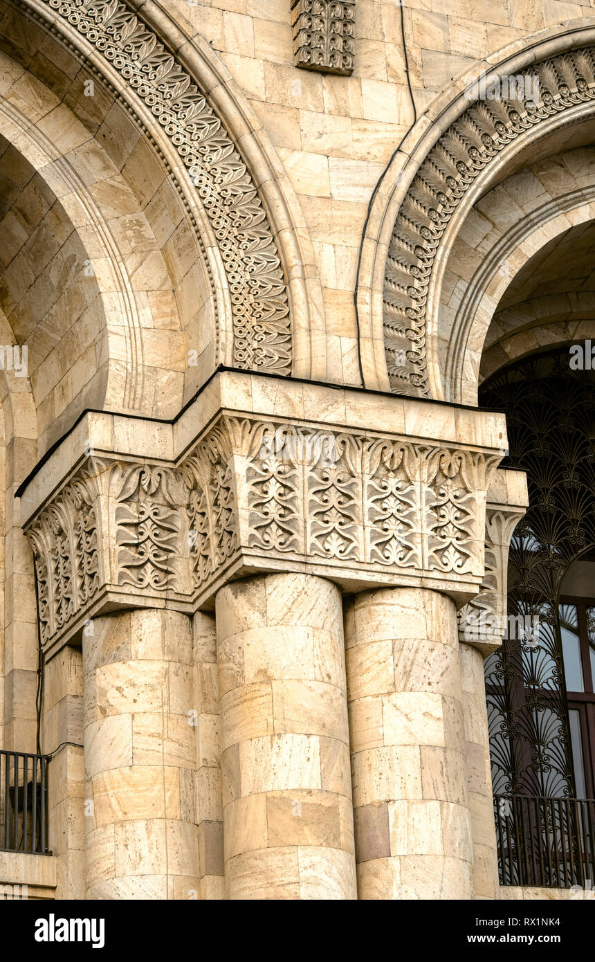 Architectural detail of the arched niche framed with carved ornament leaning on the pilaster with the capitals lying on four columns at the facade of  Stock Photo