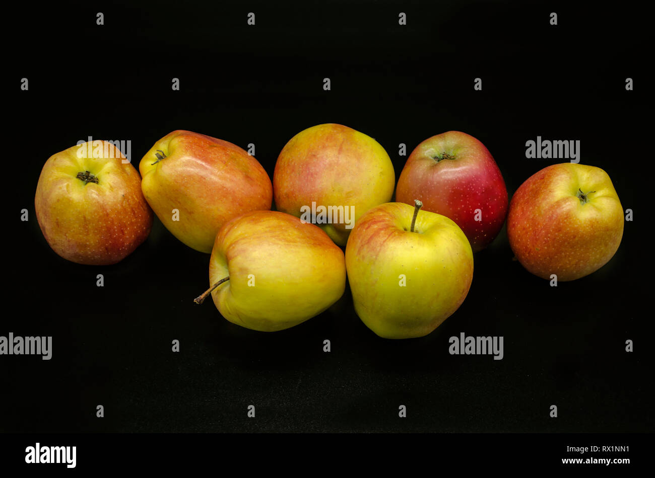 Group of beautiful yellow with red spots of ripe apples on a black