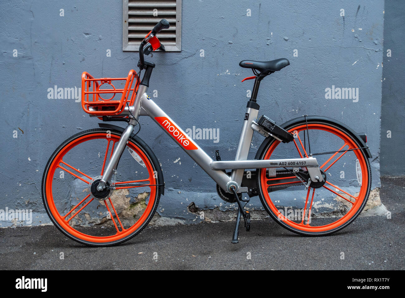 Bike sharing with shared transportation for convenient short urban trips on this Mobike hire pushbike leaning against a wall in Soho, London Stock Photo