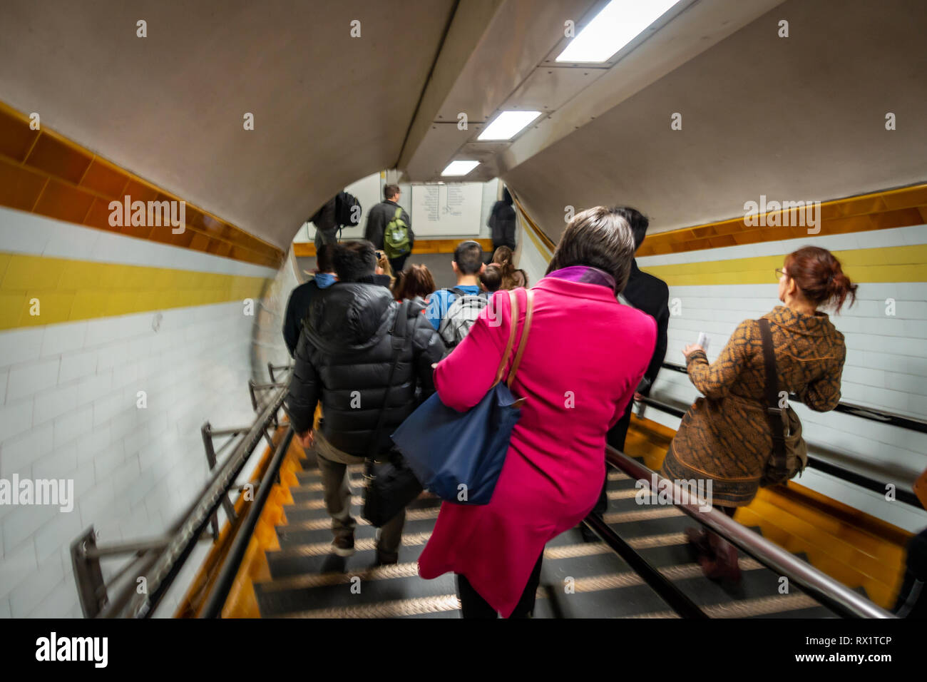 Rear view of Rush Hour Underground Tube commuters time as they travel down the stairs and passageways leading to the Tube in London Stock Photo