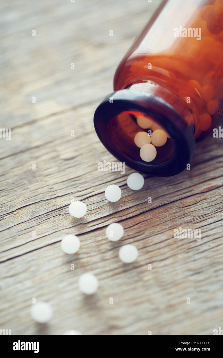 Scattered homeopathic globules and bottle. Homeopathy medicine. Stock Photo