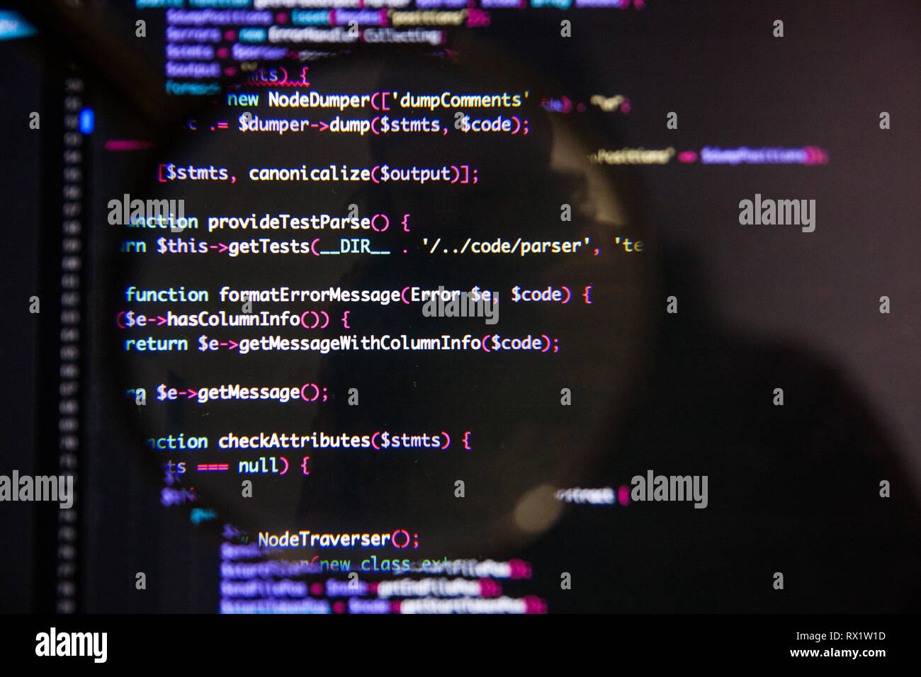 Program code visualization illustrative concept on display screen through magnifying glass Stock Photo
