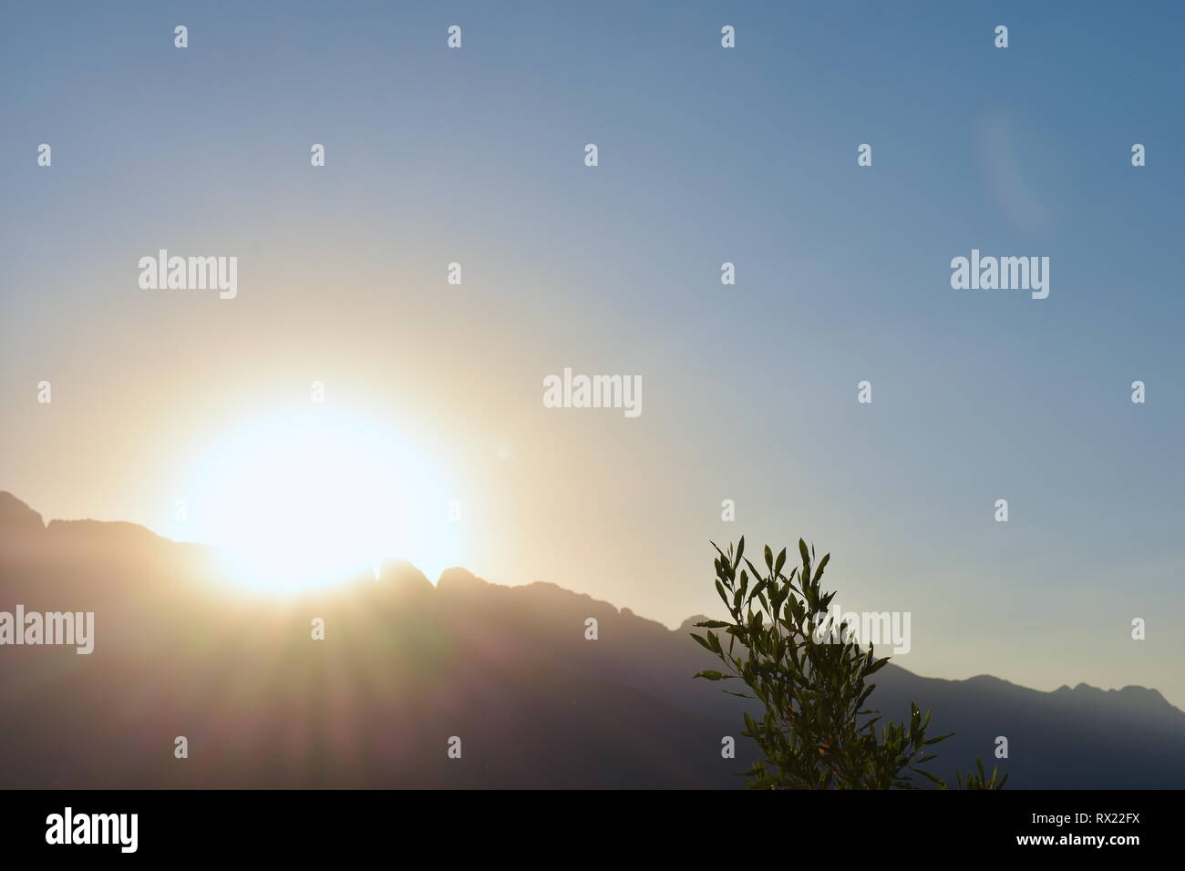 photo of direct sunlight shining over the mountains Stock Photo