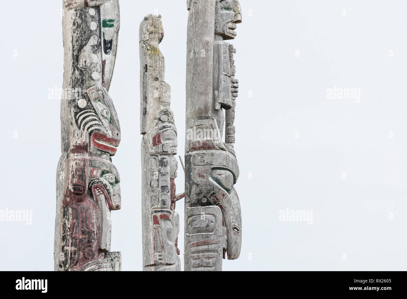 Weathered totem poles stand facing the sea at the Namgis burial ground on Cormorant Island.  Alert Bay, British Columbia, Canada. Stock Photo