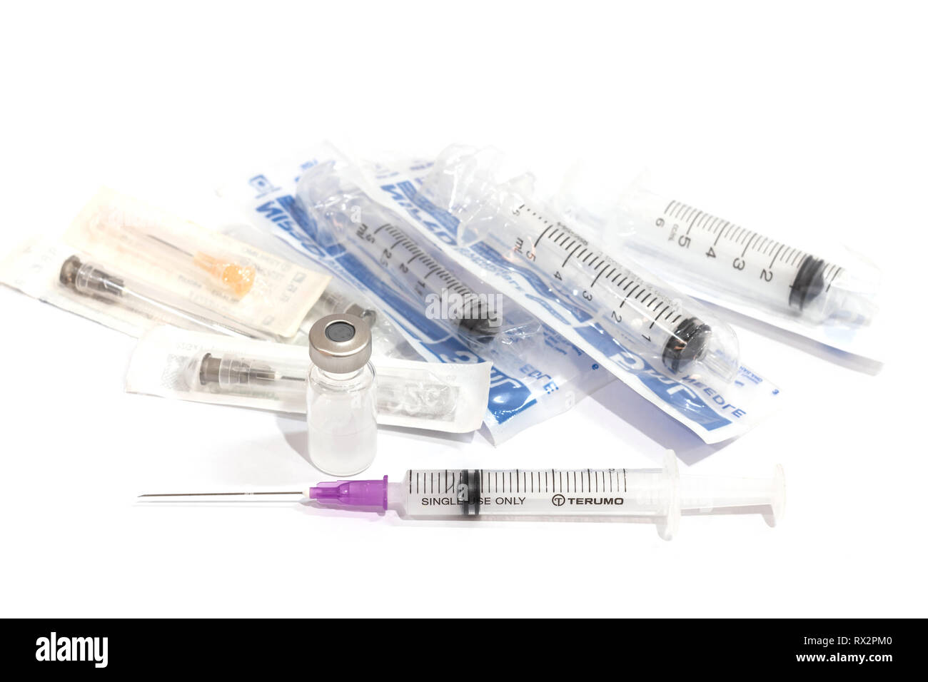 Vials with medication and injection needle isolated on white background