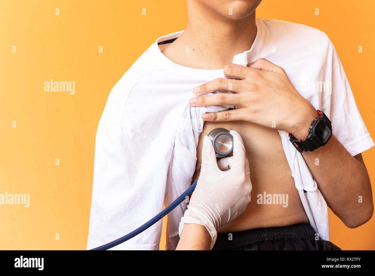 Doctor examining heartbeat of boys with stethoscope Stock Photo Alamy