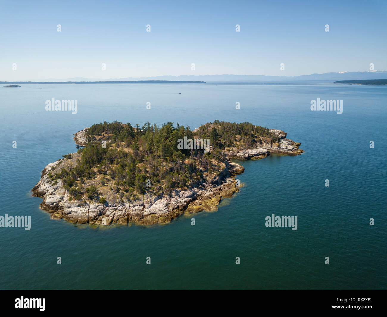 Aerial view of a rocky island during a vibrant sunny summer day. Taken near Powell River, Sunshine Coast, British Columbia, Canada. Stock Photo