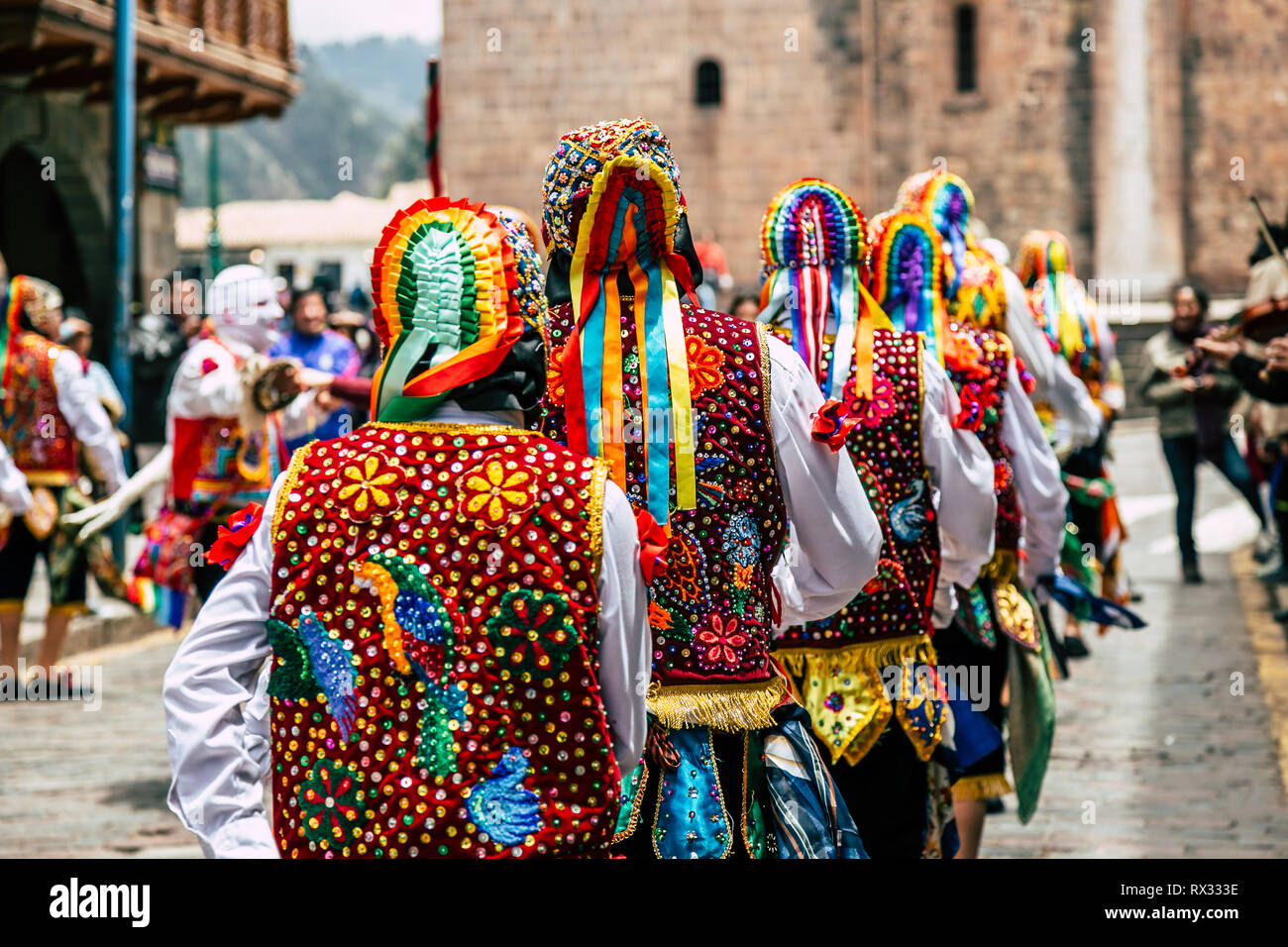 Men walking in line wearing vibrant embroidered traditional clothing during Inti Raymi or Sun Festival celebration in Cusco, Peru. Stock Photo