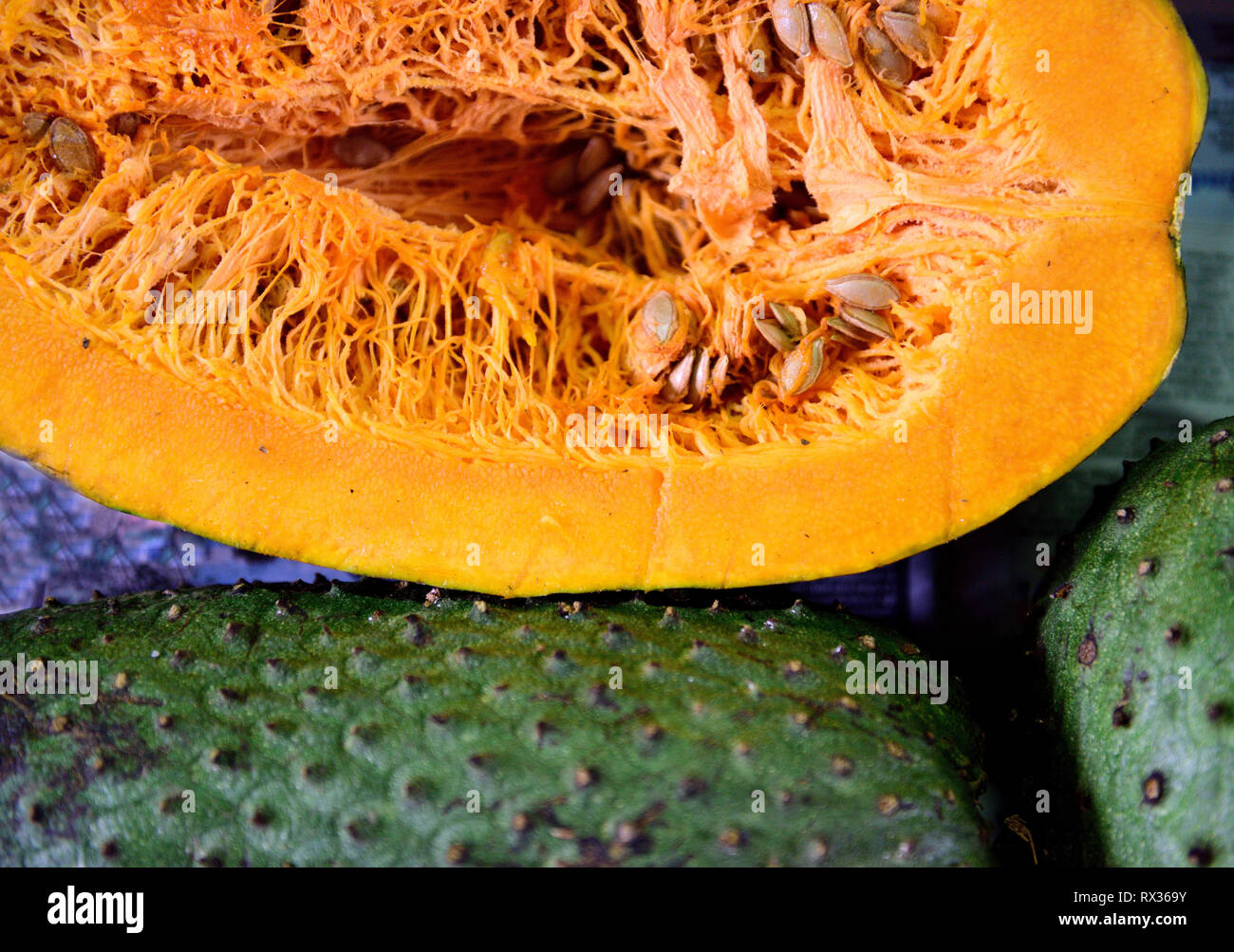 Squash fruit alongside a soursop fruit, annona muricata or Colombian