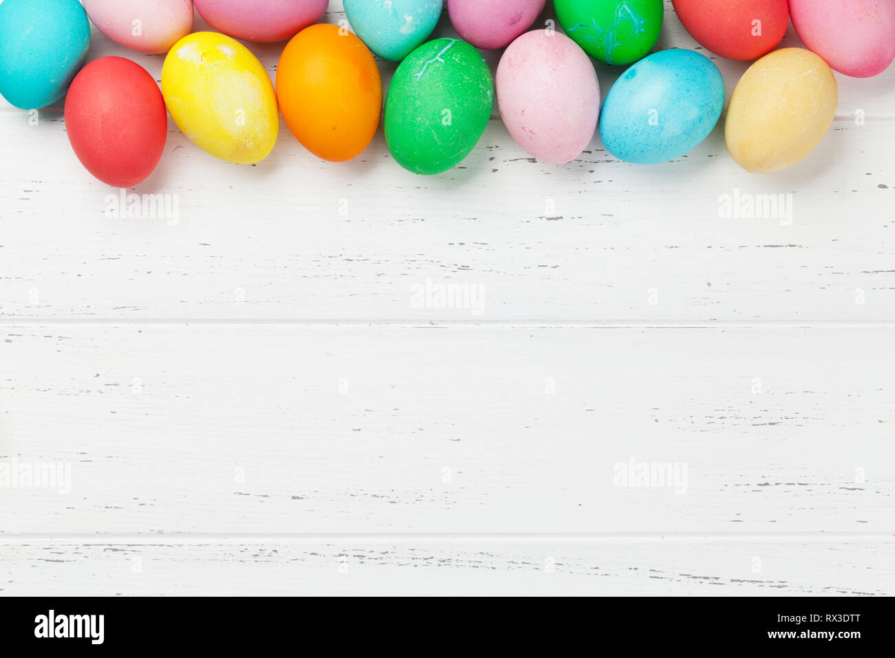 Easter greeting card with colorful easter eggs. Top view on wooden ...