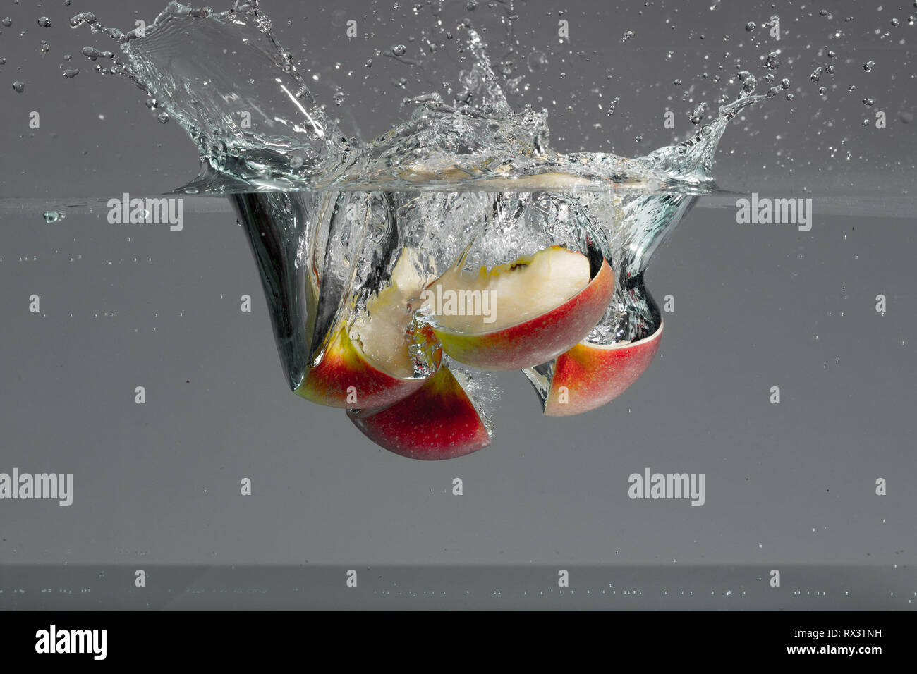 Red Apple Slices Fall Into Water And Create Beautiful Air Bubbles And Water Splashes Stock Photo Alamy