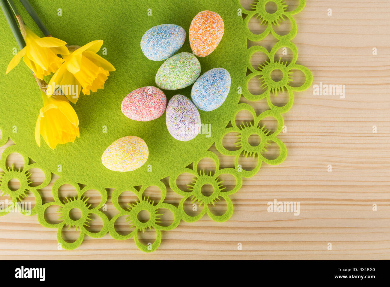 Spring Easter composition of eggs and narcissus flowers on wooden background Stock Photo