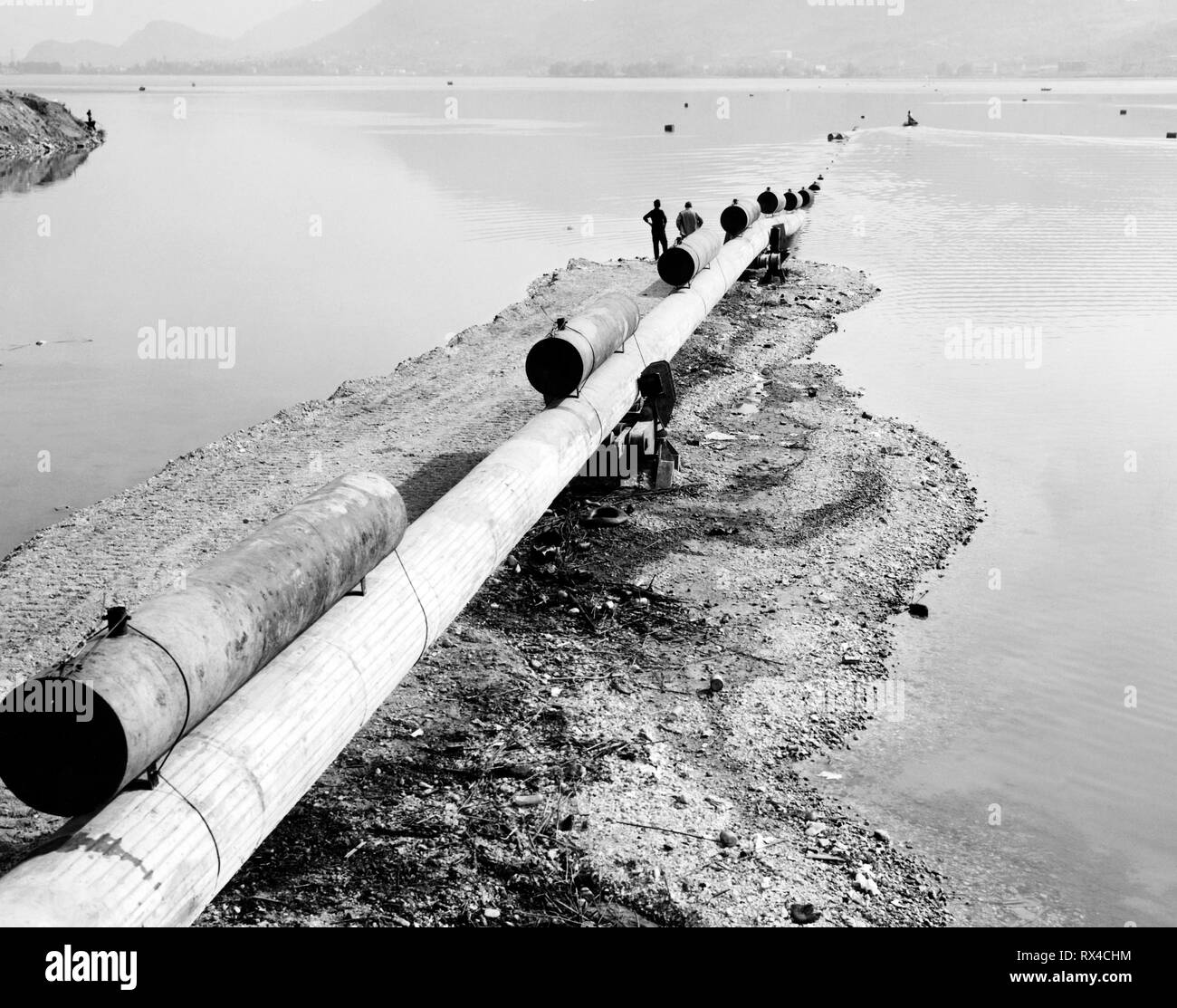 oil pipeline on garlate lake, italy 1964 Stock Photo