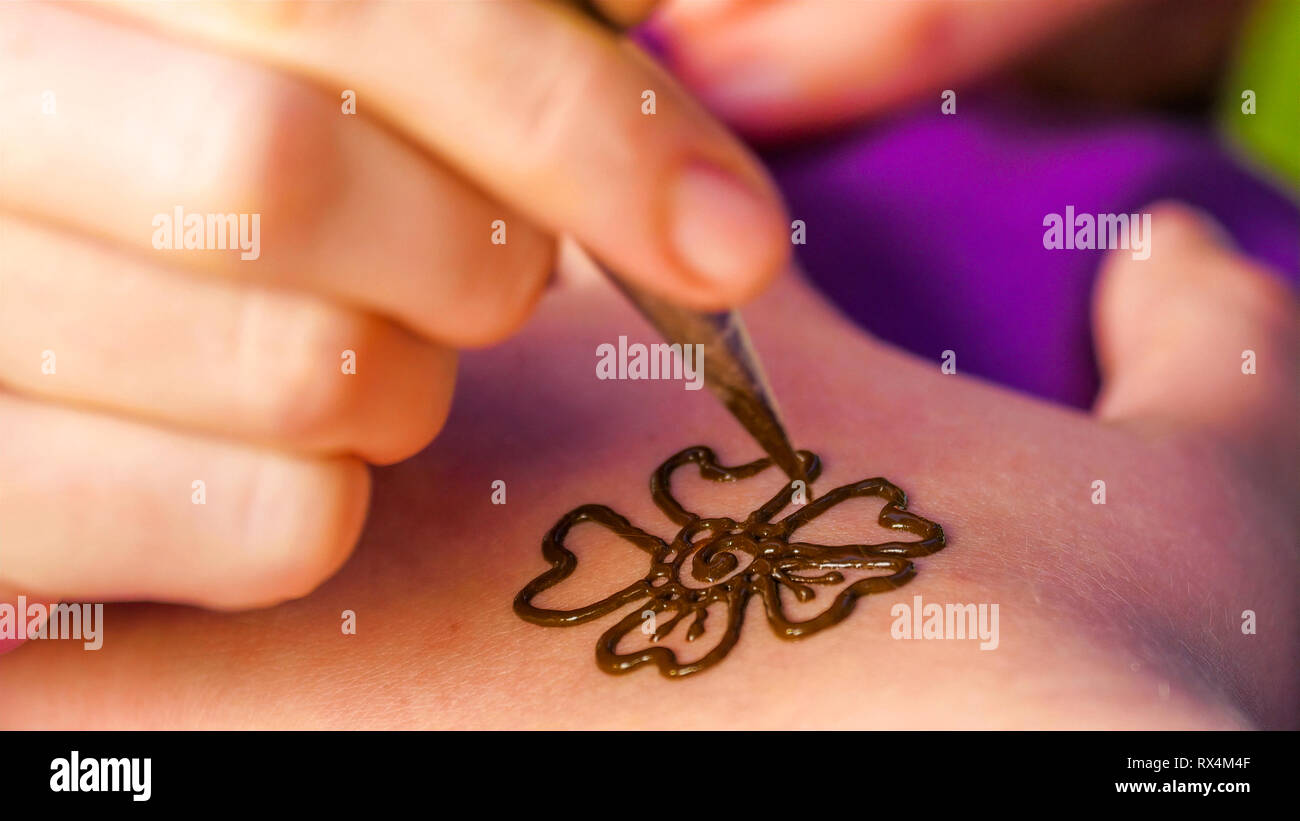 The flower design on a henna tatoo drawn on the ladys arm during a festival Stock Photo