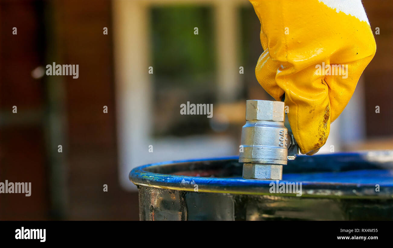 Putting up the blue faucet on the drum. It is a water drum in the city