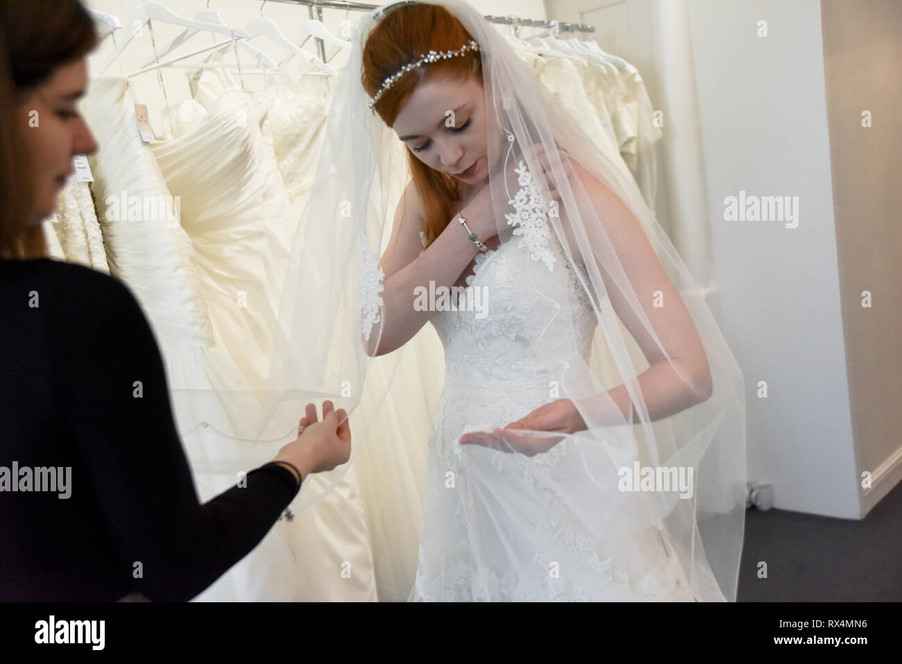 A Pretty Red Haired Girl Is Shopping For A Wedding Dress In A